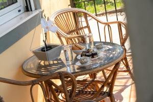 a glass table with two chairs on a porch at Villa Trigona in Kalabaka
