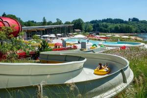 a group of boats in a water park with people in a raft at Etape motards chez Fred et Flo in Compreignac