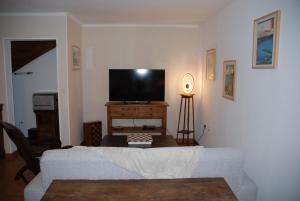 a living room with a couch and a flat screen tv at Etape motards chez Fred et Flo in Compreignac