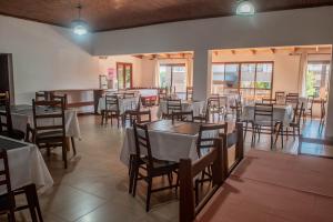 a restaurant with tables and chairs in a room at Hotel Tierra Colorada in Puerto Iguazú