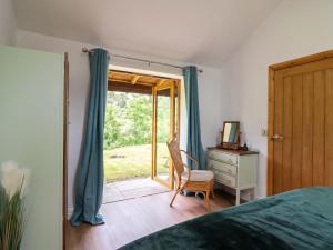a bedroom with a bed and a sliding glass door at Henlle Home Farm in Oswestry