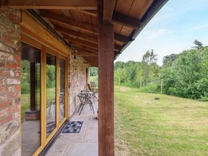 a porch of a brick house with a table and chairs at Henlle Home Farm in Oswestry