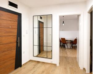 a hallway with a glass door and a table at Teslić CITY Apartment in Teslić
