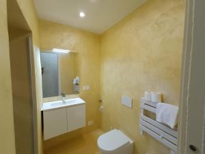 a bathroom with a toilet and a sink and a mirror at Suite Arcobaleno in Deiva Marina +24 photos