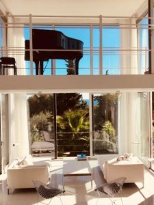 a living room with a piano and white furniture at Villa Mirano in Éze