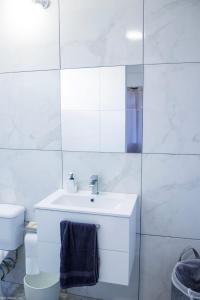 a white bathroom with a sink and a toilet at Beach Bay Terrace with Mountain views in Buccament