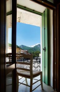 Ein Stuhl steht auf einem Balkon und schaut aus dem Fenster in der Unterkunft Rum Oliero in Valbrenta 
