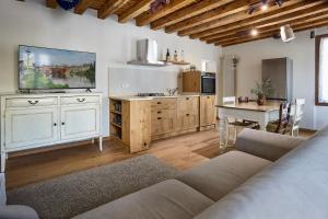 ein Wohnzimmer mit Sofa und eine Küche mit Tisch in der Unterkunft Rum Oliero in Valbrenta 