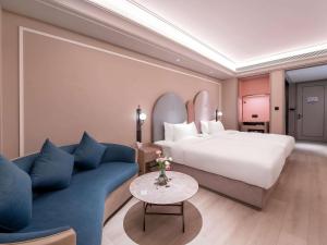 a hotel room with a bed and a couch at Mercure Chengdu Longtan in Chengdu