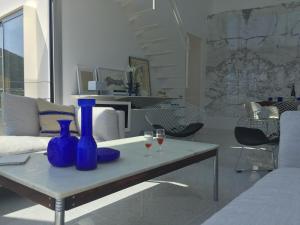 a living room with blue vases and wine glasses on a table at Villa Mirano in Éze