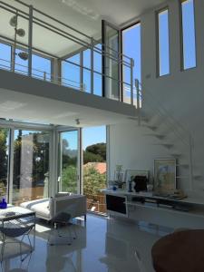 a living room with a staircase and a couch and chairs at Villa Mirano in Éze