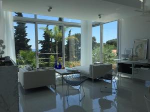a living room with a table and chairs and windows at Villa Mirano in Éze +69 photos