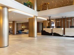 a lobby of a hotel with columns and a bar at Mercure Sofia City in Sofia