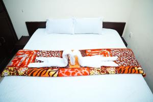a bed with a colorful blanket on it at SV Grand in Kākināda