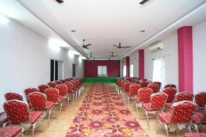 an empty room with red chairs and a aisle at SV Grand in Kākināda +10 photos