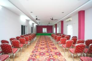 an empty room with red chairs and a carpet at SV Grand in Kākināda