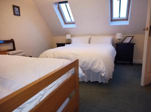 a bedroom with two beds and two windows at Castle Road in Castletown