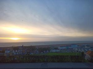 a sunset over a city with houses and the ocean at Castle Road in Castletown