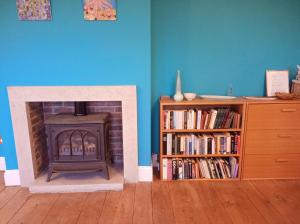 a living room with a fireplace and a book shelf at Castle Road in Castletown