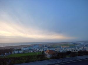 a view of a town with houses and the ocean at Castle Road in Castletown