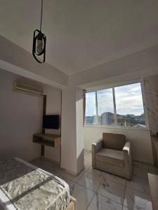 a bedroom with a bed and a chair and a window at Hotel Rozafa Velipoje in Baks-Rrjoll