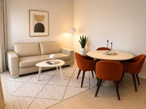 a living room with a couch and a table and chairs at Monte Aria panorama suites in Herceg-Novi