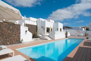 a villa with a swimming pool in front of a house at La Concha Boutique Apartments - Adults Only in Arrecife