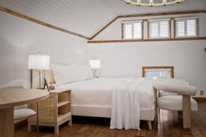 a white bedroom with a bed and a table and chairs at Chic Retreat on Broadway Street in Grove City