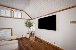 a living room with a flat screen tv on the wall at Chic Retreat on Broadway Street in Grove City