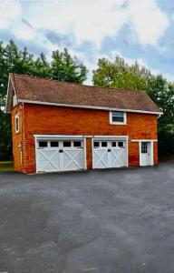 a red brick garage with two white garage doors at Chic Retreat on Broadway Street in Grove City