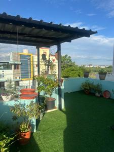 a balcony with potted plants and a roof at The ARCS in Madurai