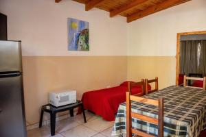 a room with two beds and a tv on a table at El Rosedal Cataratas in Puerto Iguazú
