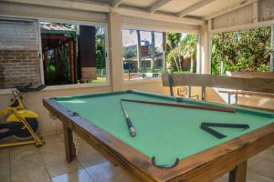 a green pool table in a room with windows at El Rosedal Cataratas in Puerto Iguazú