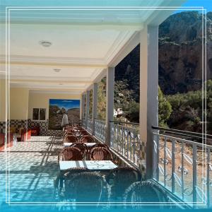 a balcony with a pool with chairs and a view at Auberge Bab chellalat in Tamarout