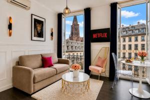 a living room with a couch and a table at LIFE CATHEDRALE City-Center Place Gutenberg in Strasbourg