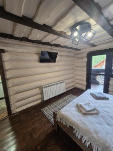 a bedroom with a bed in a room with wooden walls at Synevyr House 2 in Synevyrsʼka Polyana