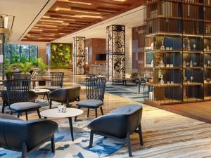 a lobby of a hotel with tables and chairs at Mercure Berau in Tanjungredep