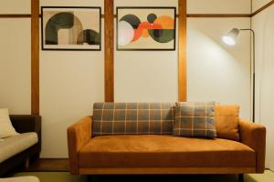 a couch in a living room with pictures on the wall at Castle Land NAGOYA Family Friendly 5min from Station in Nagoya