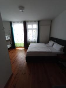 a bedroom with a large bed and two windows at Pension-Fürstenberghavel Sans Rival in Fürstenberg