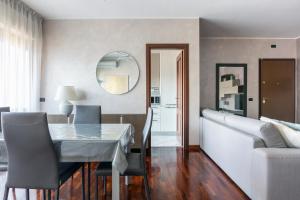 a dining room with a table and a couch at Fiera Suite Relax in Ponte Galeria