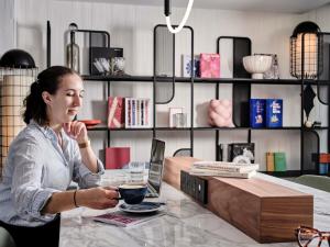 a woman sitting at a table with a glass of wine at TRIBE Paris Pantin in Pantin +112 photos