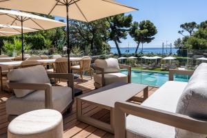 a patio with tables and chairs and a swimming pool at Radisson Hotel Cannes Seaside in Cannes