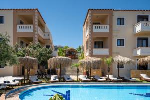 a hotel with a swimming pool in front of a building at GardenBlue By Gereoudis in Kolymvari