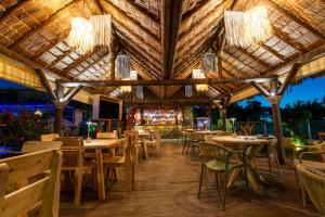 a restaurant with tables and chairs and chandeliers at GardenBlue By Gereoudis in Kolymvari