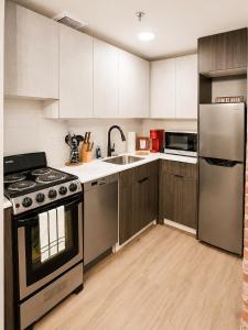 a kitchen with stainless steel appliances and wooden cabinets at Downtown Detroit Hidden Gem Walk to Venues & DMC in Detroit