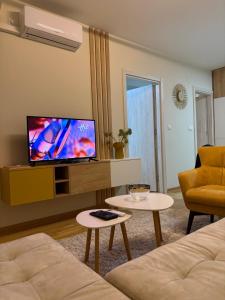 a living room with a flat screen tv on a cabinet at Astera 4 in Vrnjci