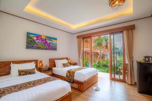 a hotel room with two beds and a balcony at Uma Nandhi Villa Ubud in Tegalalang +41 photos
