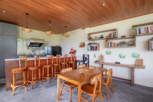 a dining room with a wooden table and chairs at Uma Nandhi Villa Ubud in Tegalalang