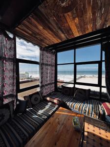 a living room with a couch and large windows at Imsouane petitsurfer SurfCamp & Yoga in Imsouane
