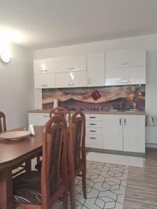 a kitchen with a wooden table and two chairs at Pod jedľou in Liptovský Trnovec